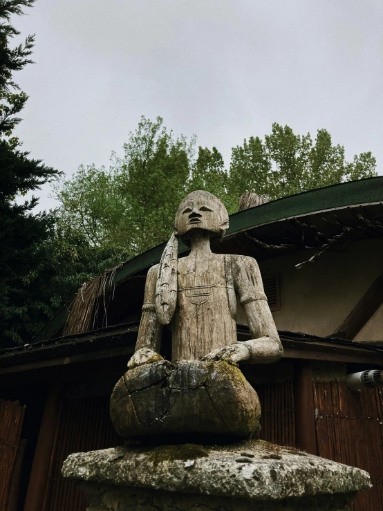 a statue in front of a building with the treeline