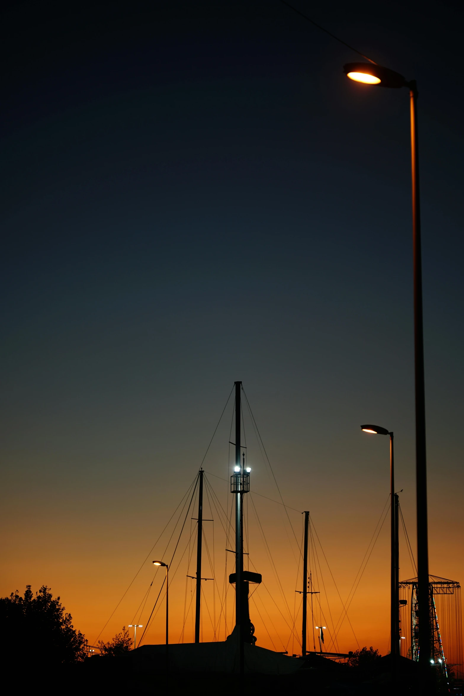 the sun is setting behind the sailboats