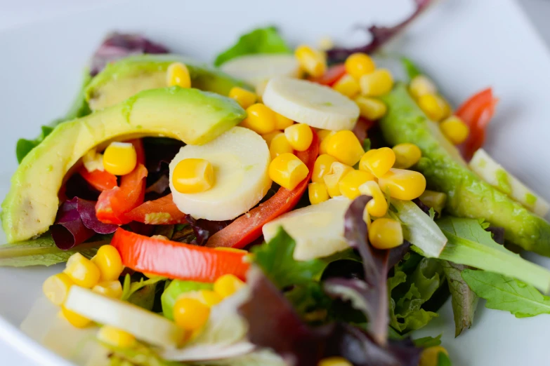 a white plate topped with salad and mixed veggies