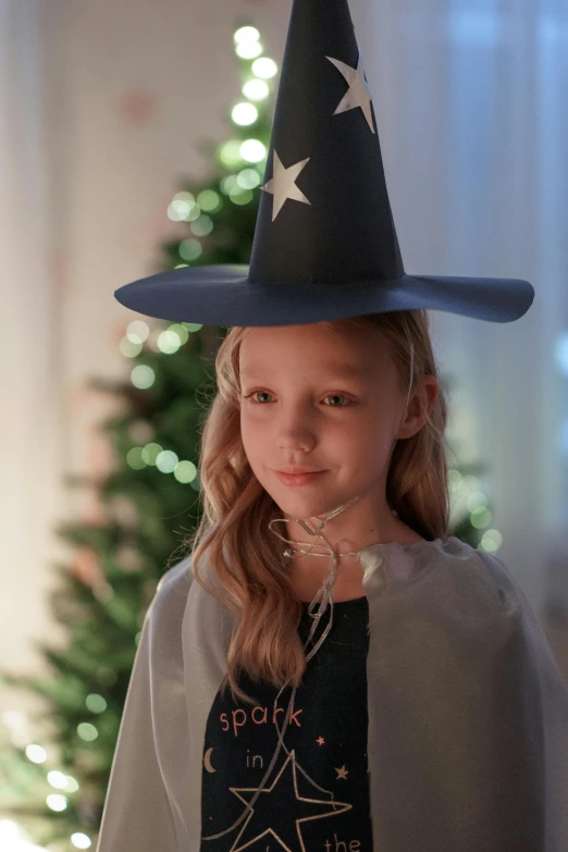 a little girl wearing a witches hat with the word cook on it