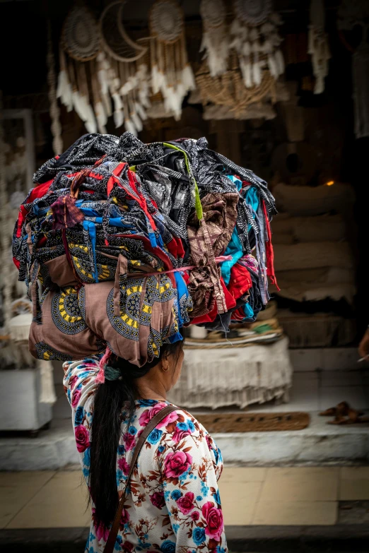 there is a woman carrying an arrangement of scarves on her head