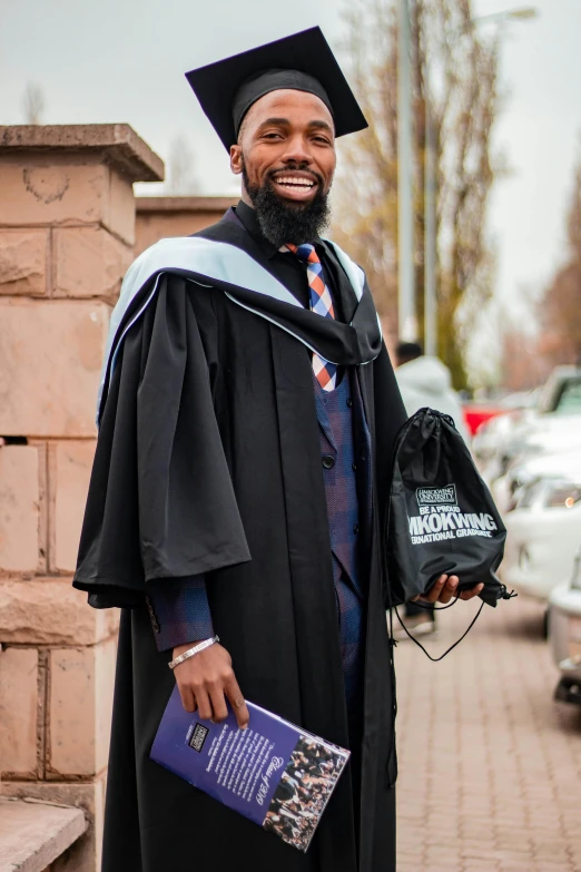 the man is smiling at the camera wearing his graduation gown