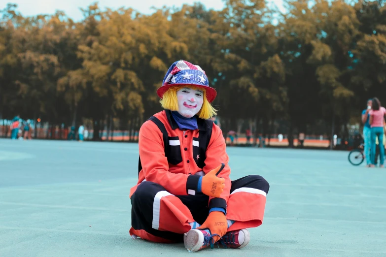 a child wearing red sits on the ground, smiling