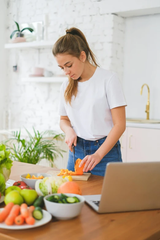 a young woman slicing fruit in her home kitchen