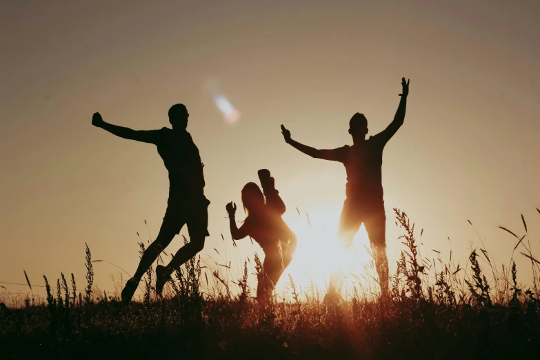 a group of people jumping into the air with their arms raised