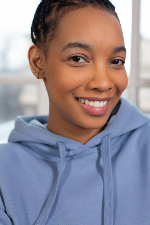 a woman smiles into the camera with her hand on her hips