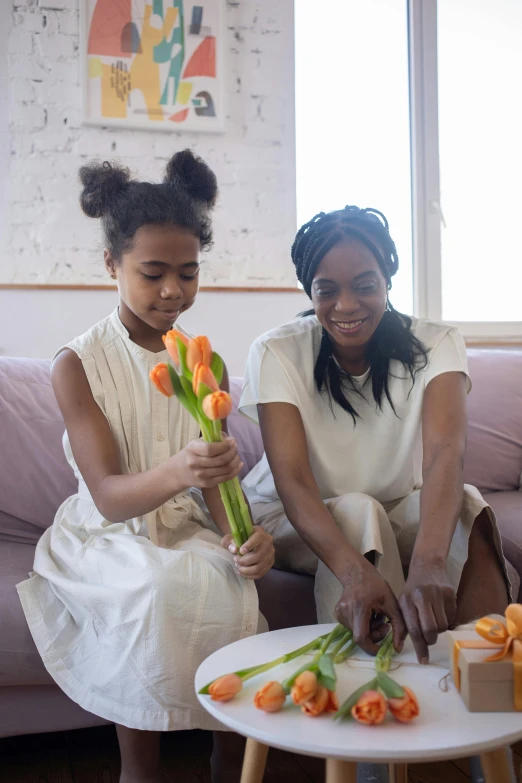 two women sitting on the couch, one  some food