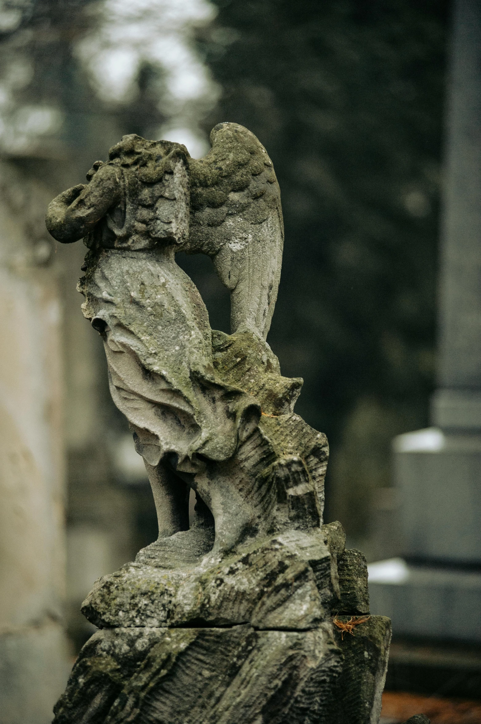 a grave with an owl statue in front