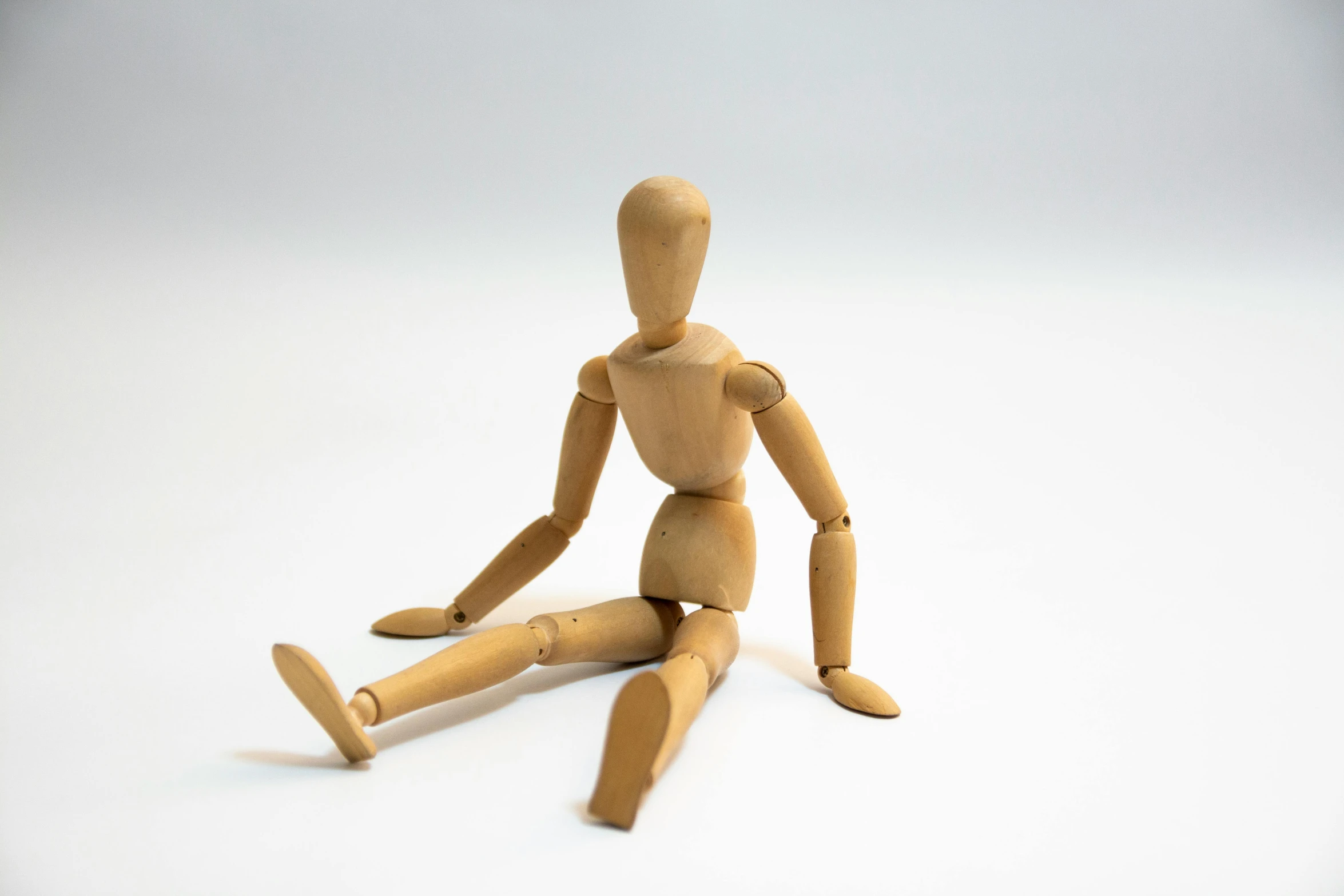 a small wooden doll sitting on the floor