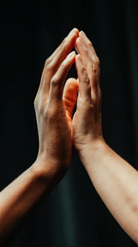 the hands of two people standing up high in the air