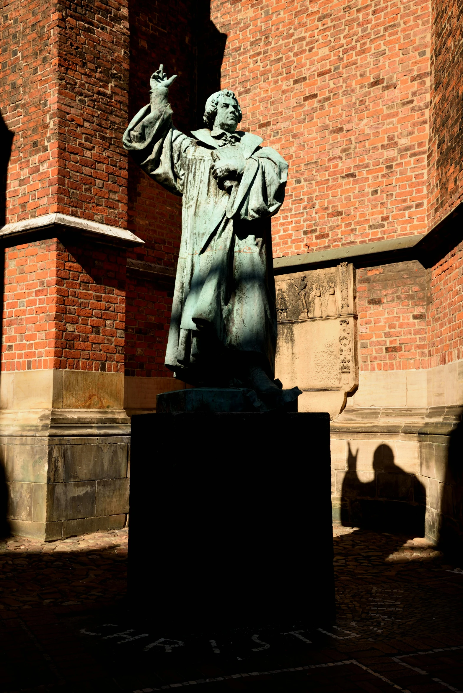 a statue is in front of a red brick building