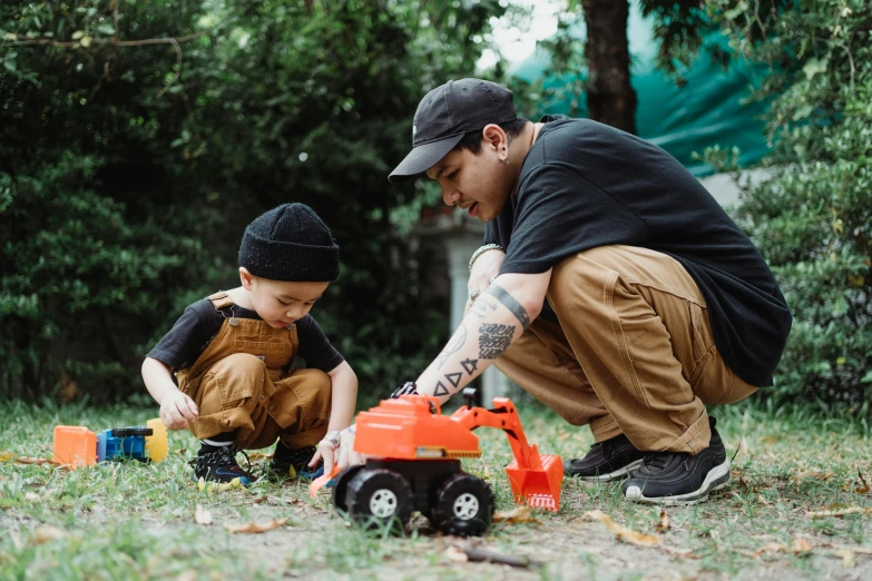 there are two boys playing in the grass with a toy