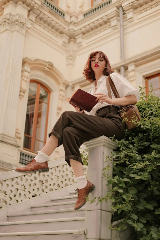 a woman sitting on a stair case reading a book