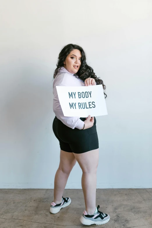 a woman in a skirt is holding a sign