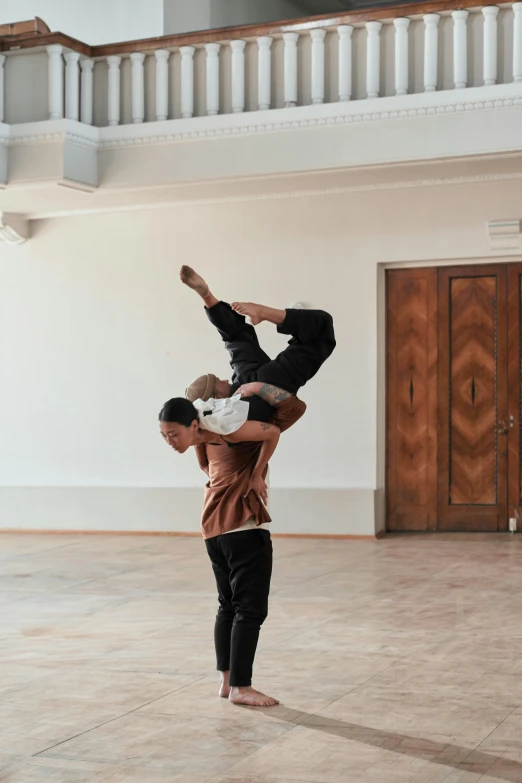two men performing a handstand on a dance floor