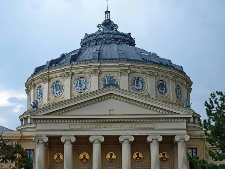 an elaborate domed building with three pillars and clock faces