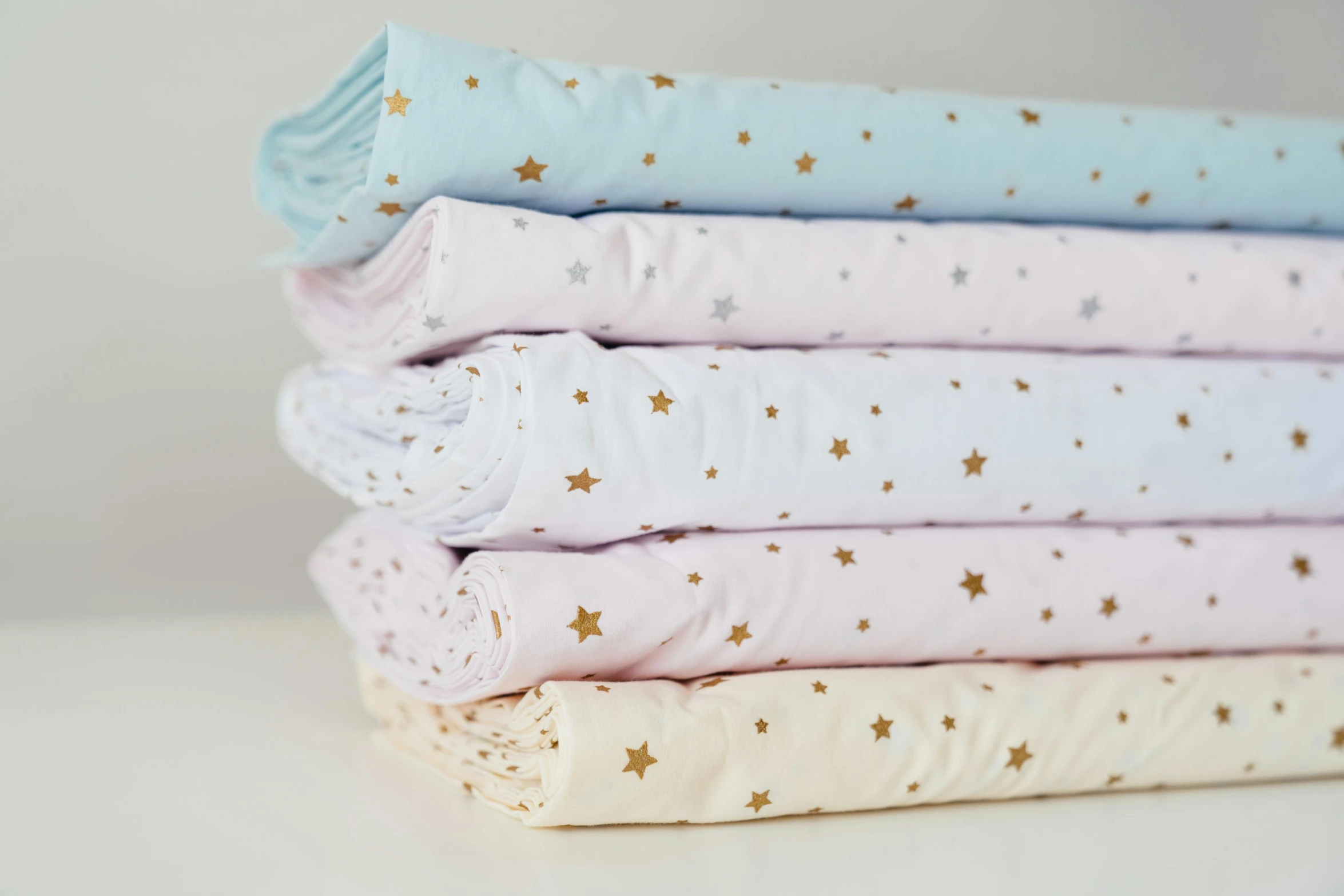 a stack of folded pink and blue sheets