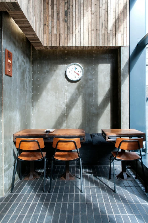 chairs and table in a room with a clock on the wall