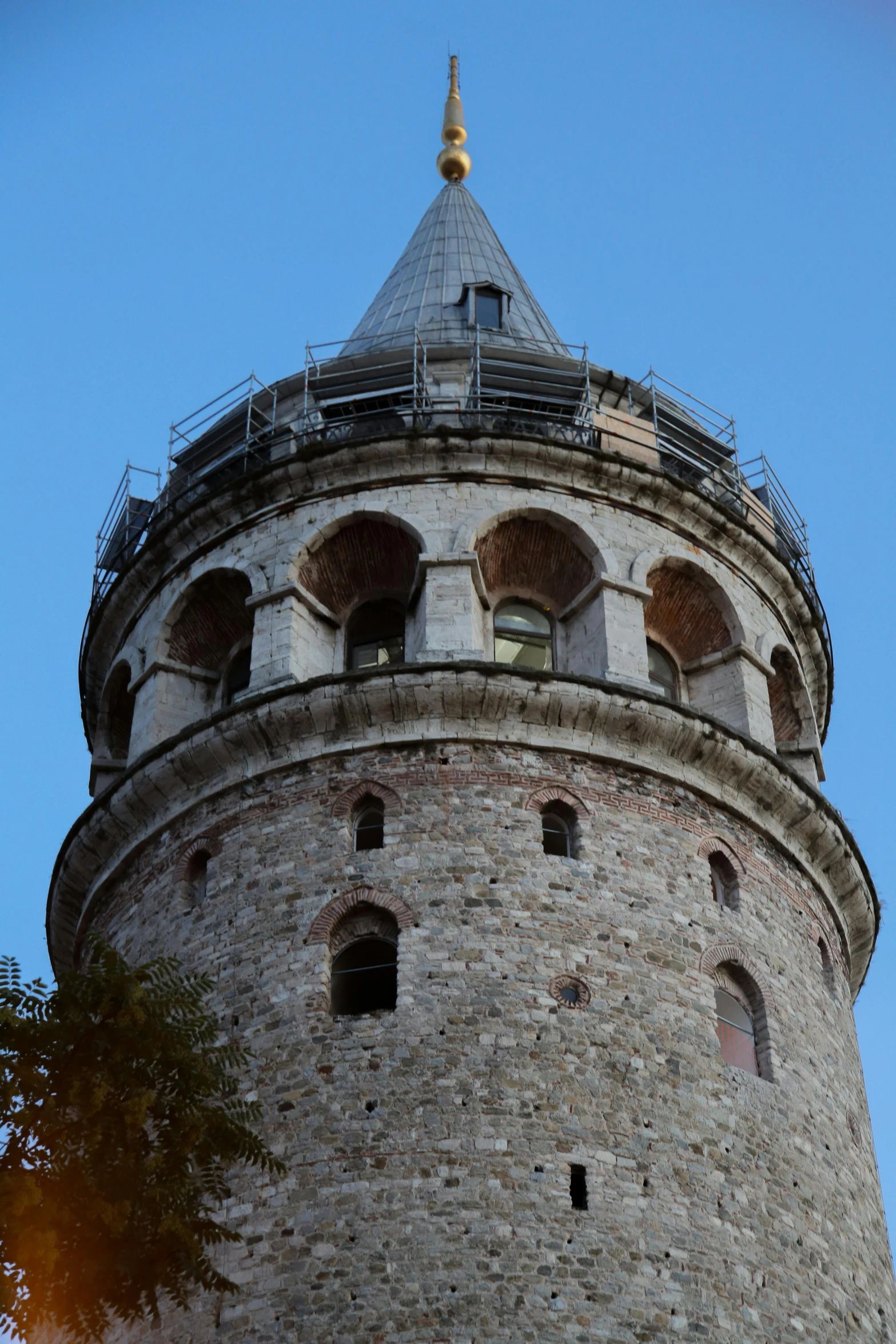 a large brick tower with a steeple near trees