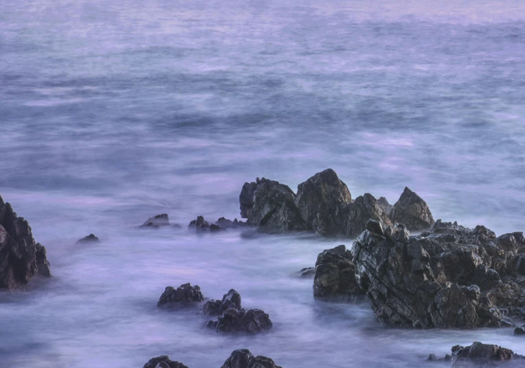 the waves break over a rocky coastline