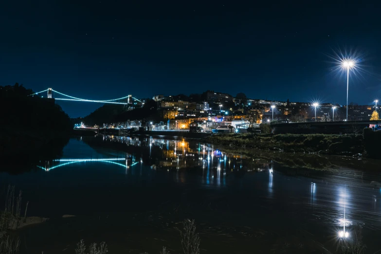 a city scene with the lights on and reflecting in water