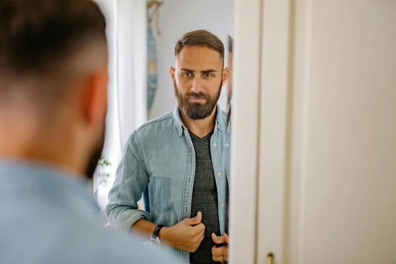 man standing in front of mirror combing his hair