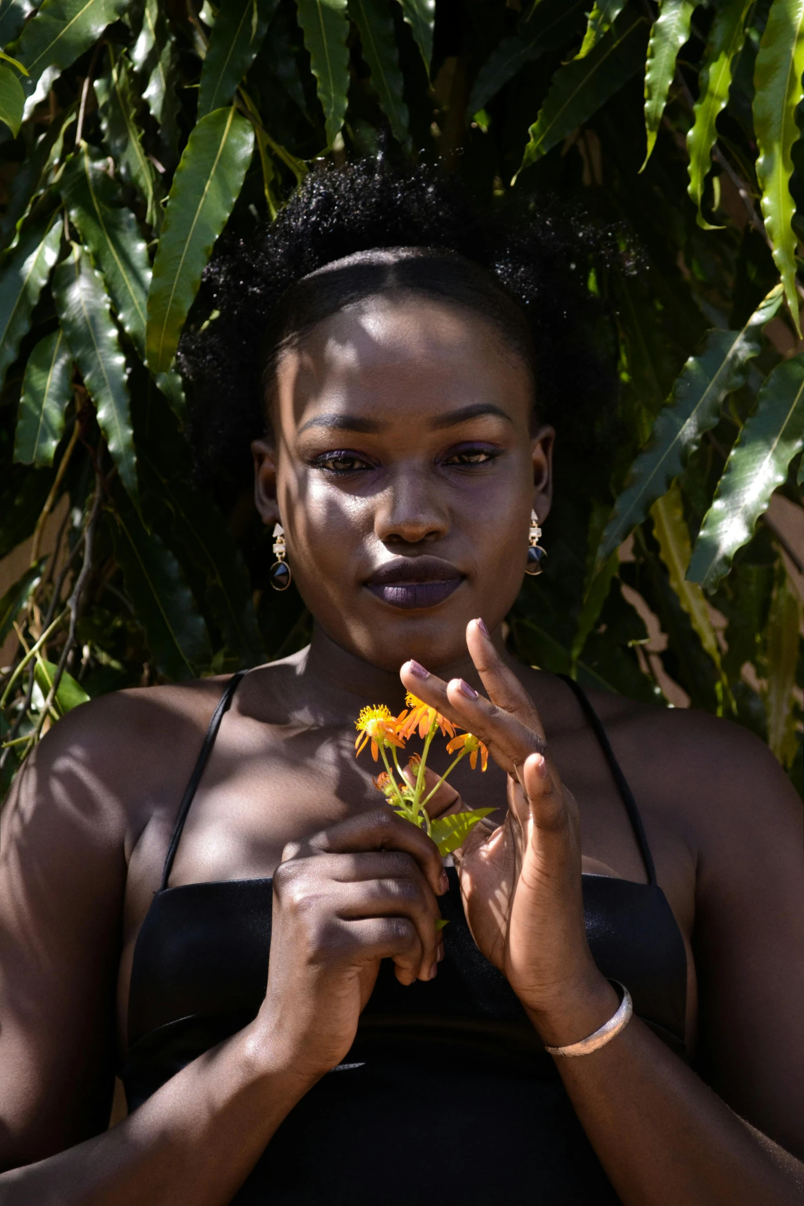 a woman with one hand on her face and flower