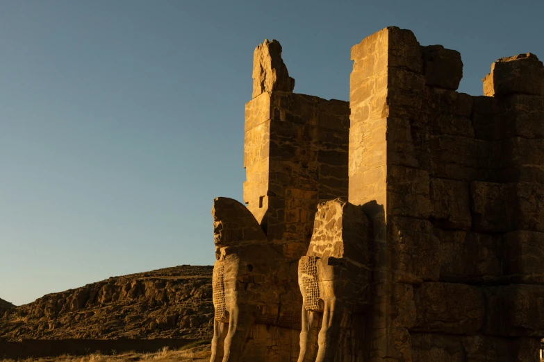 a couple of statues near a stone wall