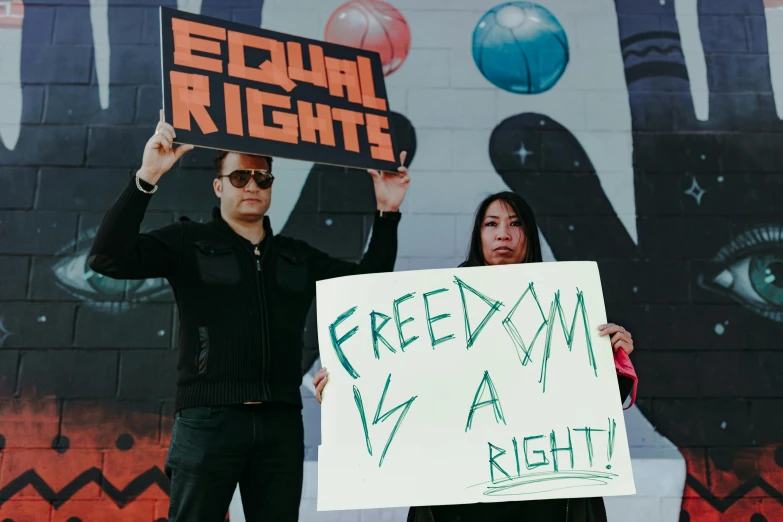 a woman holding up a sign beside a man