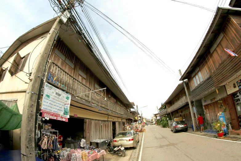 an asian village has wooden buildings along the street