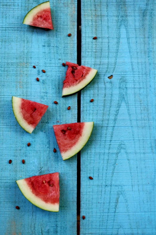 slices of watermelon on blue painted wood