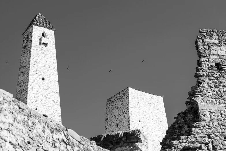 two stone towers towering over a city wall