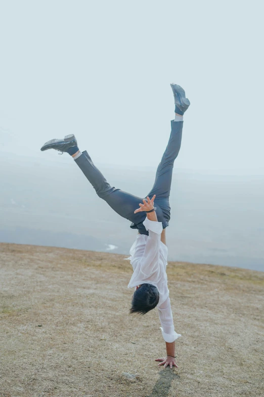 a man is doing a handstand on top of the hill
