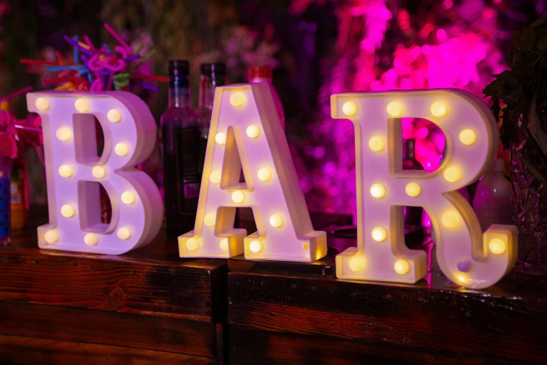 a lighted bar sign sits on a shelf