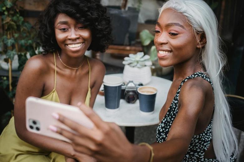 two beautiful young women sitting outside with an ipad