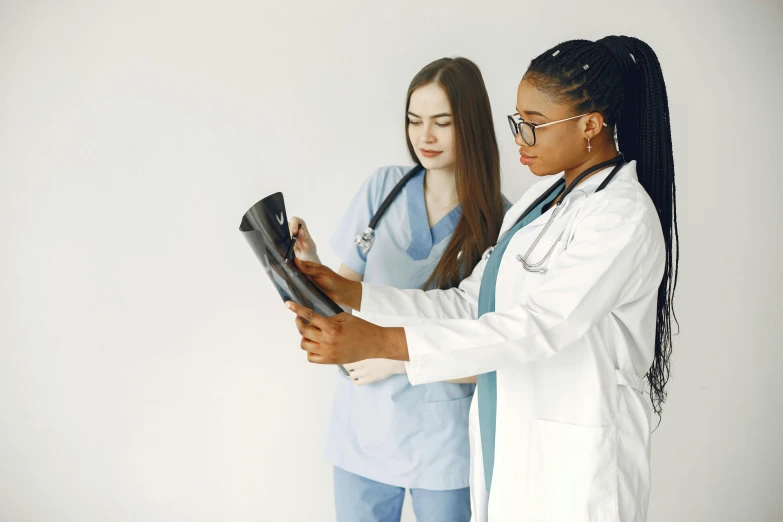 two young women dressed as nurses holding onto a computer