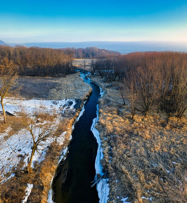 there is snow and the river in the country side