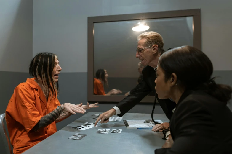 four people sitting at a table talking and playing cards