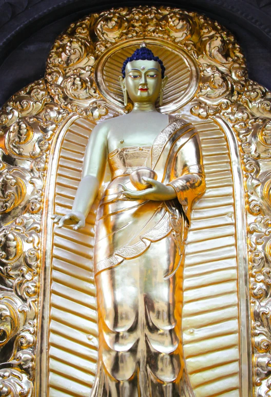 gold buddha statue in gold, with an intricate design around it