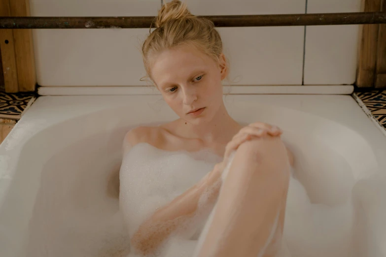 a girl is in the tub taking a bath