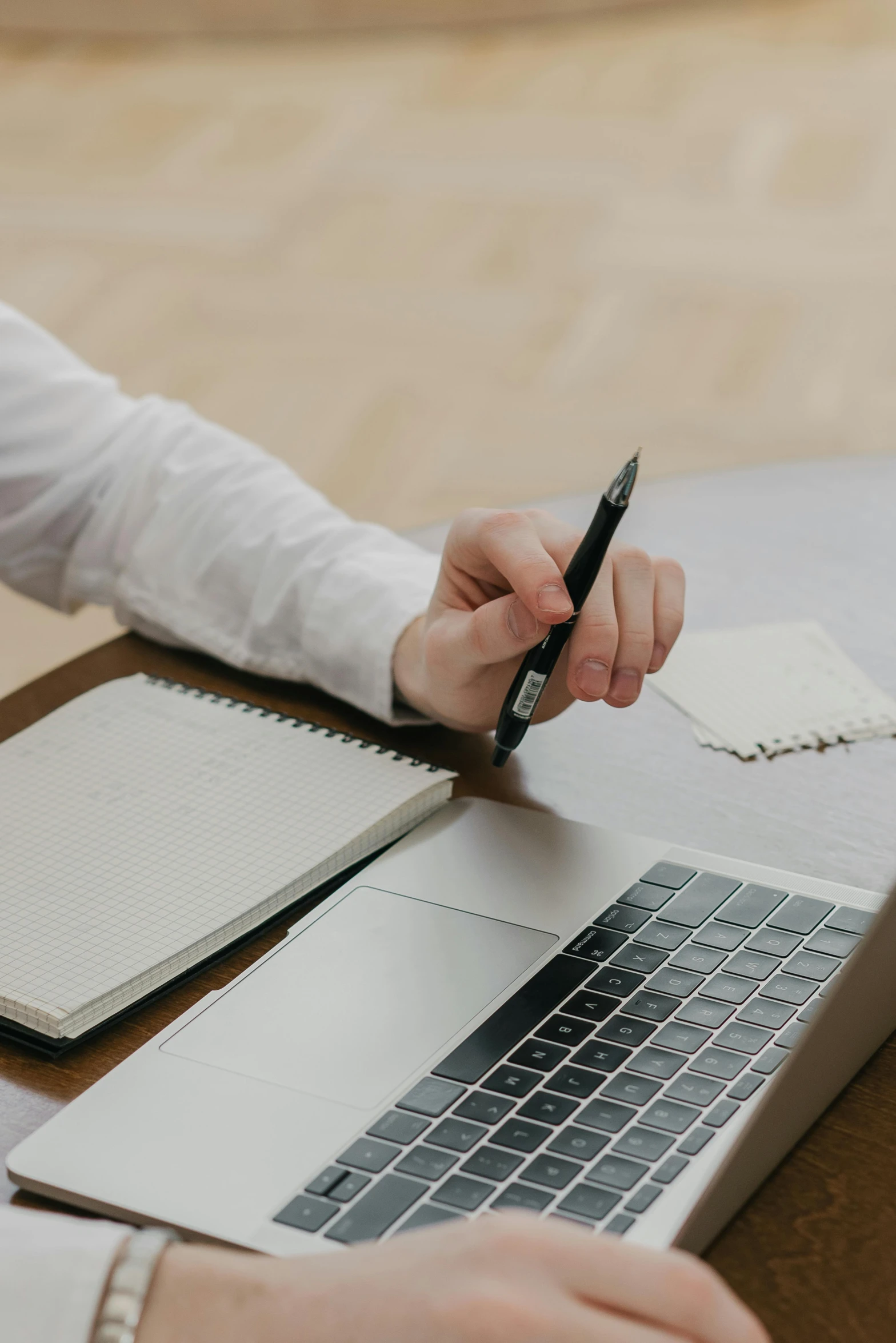 a woman writing in an notebook on her laptop