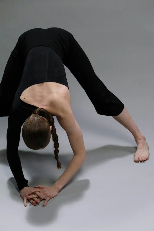 a  doing a hand stand while wearing a black shirt and skirt