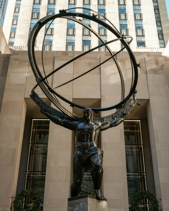 a statue has a large metal wheel around it's body