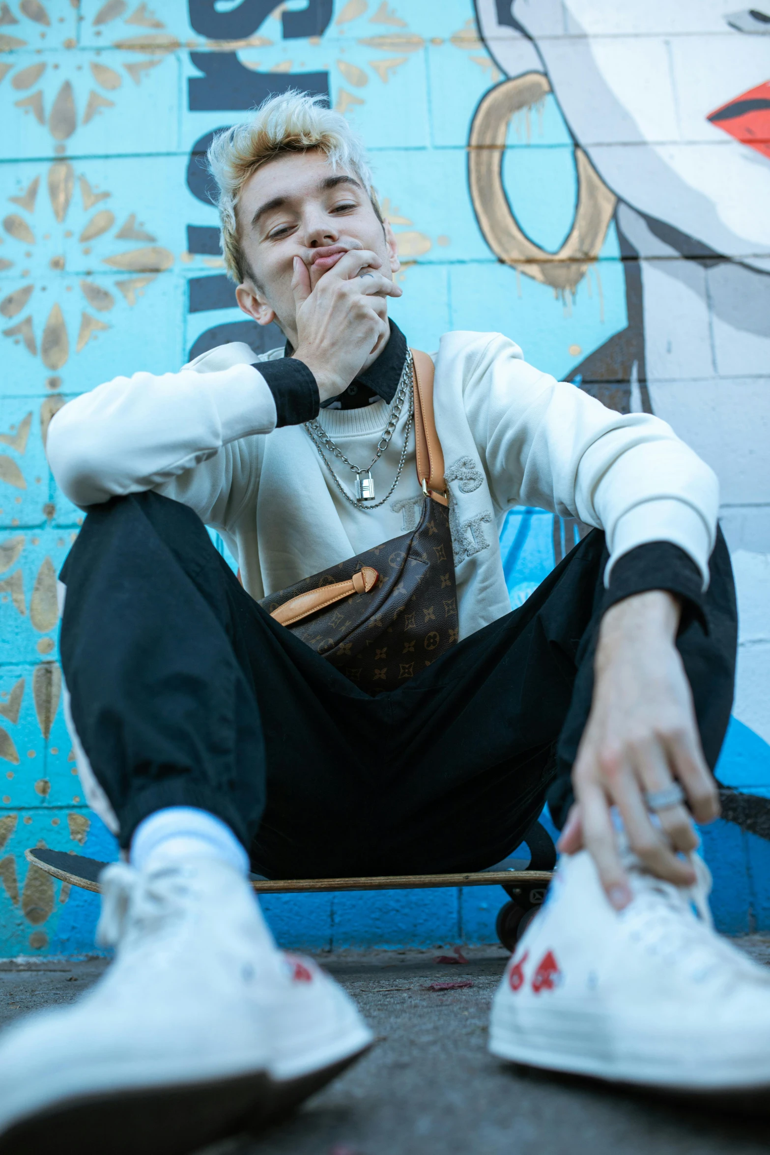 a man smoking a cigarette sitting on the ground