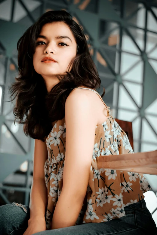 a beautiful young lady sitting on top of a wooden chair