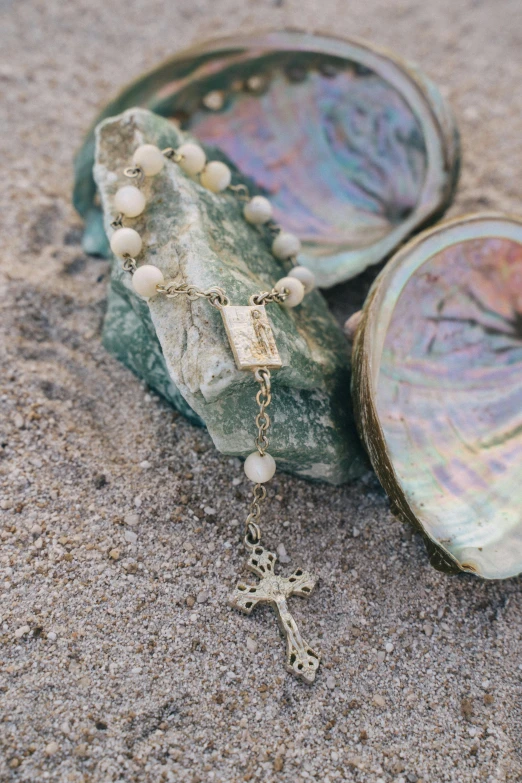 rosary with white pearl beads on the sand
