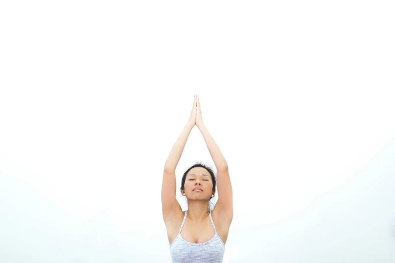 a woman doing yoga while holding her hands in the air