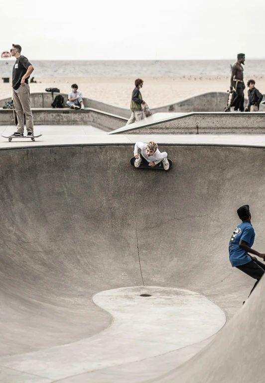 a guy sitting on a skateboard inside a pool