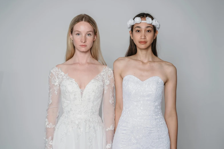 two models wearing wedding dresses with long sleeves