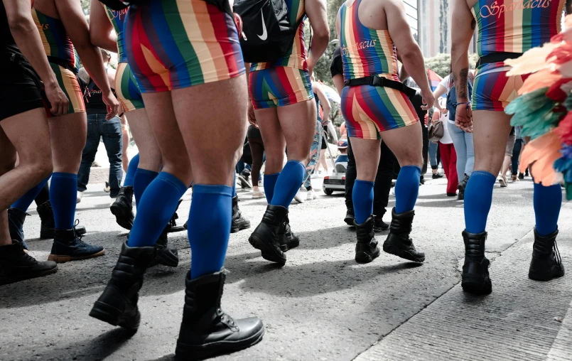 a group of colorful  men walk down the street